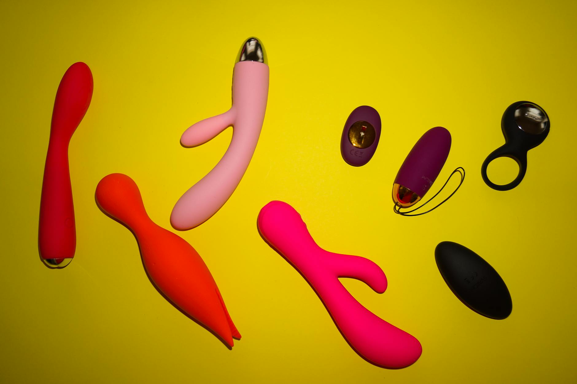 Colorful lemon vibrators and sex toys arranged on a bright yellow surface